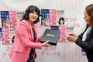 ユーチューブの公式チャンネルの登録者数が10万人を超え、「銀の盾」を受け取る片山財務相(左)=18日午後、国会