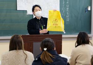 安野小学校の入学説明会で、体操着袋の寄贈について説明する市社会福祉協議会の職員=阿賀野市南安野町