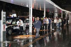 　ＪＲ甲府駅前でタクシーを待つ人たち＝２６日午後１１時２２分、甲府市