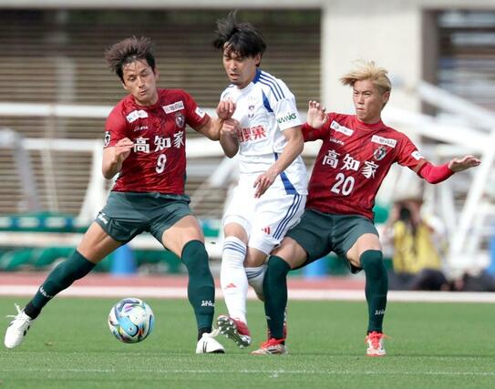 後半、競り合うＭＦ白井（中央）＝４月１２日、高知市のＧＩＫＥＮスタジアム