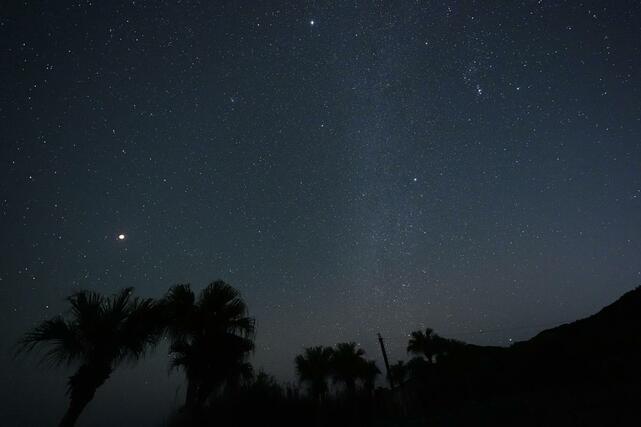 宮崎県日南市で、天の川などの星々と“競演”する皆既の月（左）＝３日午後８時３５分（８秒露光）