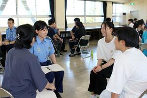 初任科生と和やかな雰囲気で会話する高校生ら=新潟市西区小新西2