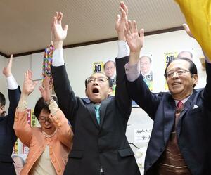 阿賀野市長選で当選を確実にし、万歳する加藤博幸氏（中央）＝２１日午後１０時３０分過ぎ、阿賀野市下条町