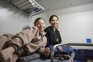 　「不屈の車両」の寝台車の２段ベッドで過ごすベロニカさん（右）ら＝１１日、キーウ近郊（共同）