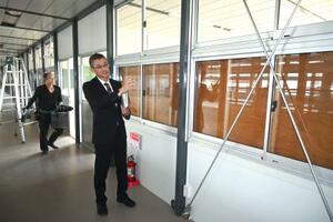 石川県立輪島高の仮設校舎内で話す高橋潤哉教頭=4日午後、輪島市