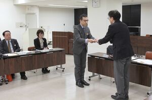 県スポーツ推進プランを県幹部に答申する西原康行副学長(左)=3月14日、新潟市中央区