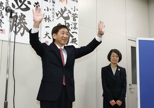 初当選を決め、両手を挙げて支持者に応える小菅淳一氏(左)=26日午後11時過ぎ、上越市藤巻