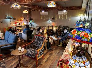 ステンドグラスの光の中で、飲食や展示販売を楽しめる「cafe RiLa」の店内=新潟市北区葛塚