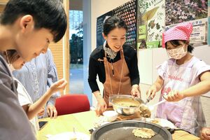 ナイトミュージアムでドングリ粉入りのパンケーキを焼く子どもたち=十日町市博物館