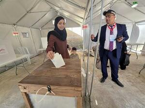 25日、パレスチナ自治区ガザ中部デールバラハで投票する女性(共同)
