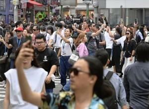 　スマホを手にスクランブル交差点を行き交う人たち＝東京・渋谷