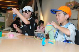 紙を使った風鈴飾りを作る子どもたち=26日、新潟市中央区