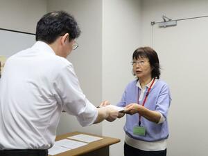 最低賃金審議会の答申に対する異議申出書を提出する県労連の寺崎洋子議長=19日、新潟市中央区