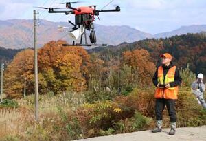 　クマが嫌がる音を出すドローンを飛ばす業者＝１４日午後、岐阜県飛騨市