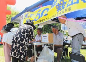 大沢孝司さんの兄・昭一さん(右)らが、特定失踪者の救出を求めて行った署名活動=6月8日、阿賀町