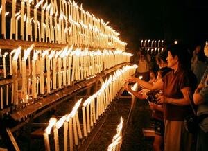 光三宝荒神社の「献灯祭」でろうそくに火をともす参拝者ら=13日夜、和歌山県橋本市