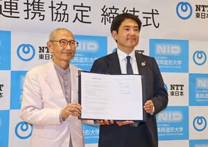 連携協定にサインした長岡造形大の平山育男学長(左)と、NTT東日本新潟支店の徳山隆太郎支店長=長岡市大手通2