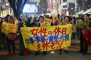 　東京・新宿駅前で行われた「女性の休日」のアクションに参加した人たち＝６日夕