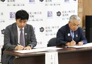 移住促進などに向けた連携協定を結んだグッドマンサービスの月花拓美社長(左)と田村正幸町長=湯沢町役場