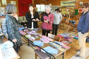作品展に向けて裂き織りを見せ合う加藤智津栄さん（左から３人目）ら＝佐渡市上横山