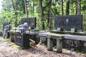 鎮魂と平和を祈り、慰霊碑と周辺を掃除する参加者=5月1日、長岡市西片貝町