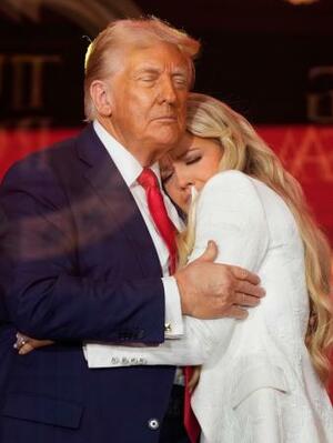 チャーリー・カーク氏の追悼式典で、カーク氏の妻(右)と抱き合うトランプ米大統領=21日、アリゾナ州グレンデール(AP=共同)
