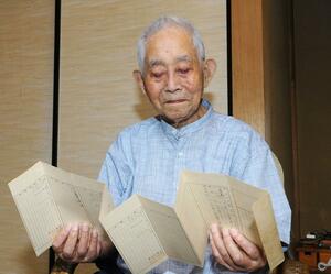 海軍での軍歴が記された書類に目を通す土橋政治さん=新潟市秋葉区