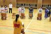 新井南小児童の手ほどきで和太鼓に挑戦する台湾の小学生=妙高市除戸の新井南小
