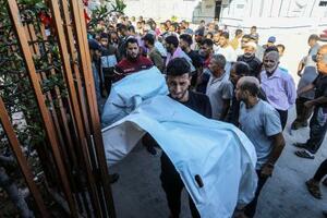 28日、ガザ南部ハンユニスで、イスラエル軍の攻撃により親族が殺害されて嘆く人たち(ゲッティ=共同)
