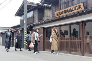 出雲崎町沿岸部に軒を連ねる妻入りの街並みを視察する地域おこし協力隊ら=出雲崎町