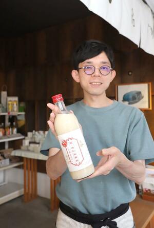 古町糀製造所が創業15周年を記念して発売した甘酒「糀・杏仁豆腐風」と小畑宏樹社長=新潟市中央区古町通2