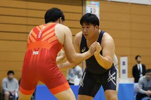 個人125キロ級2回戦 攻め手を探る赤塚晟結(青・県央工)=3月28日、新潟市東区