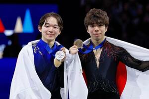 　男子の表彰式でメダルを掲げる２位の鍵山優真（左）と３位の佐藤駿＝プラハ（共同）