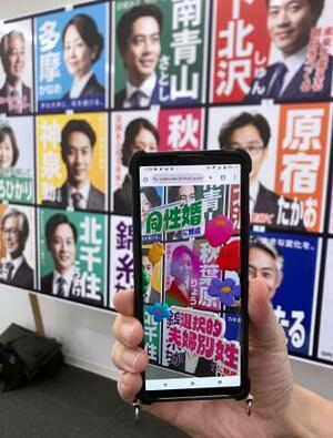 選挙ポスターにスマートフォンのカメラをかざすと法制化に賛成の候補かどうかが分かるシステム。架空の候補者のポスターを使って報道陣に公開された=6月、東京都渋谷区