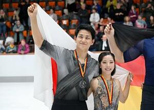 ペアで2位となり、日の丸を手にする三浦璃来(右)、木原龍一組=オーベルストドルフ(共同)