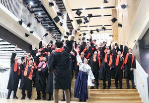 帽子を投げるハットトスで祝った三条市立大学の最初の卒業生=3月22日、三条市上須頃