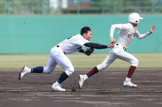 ３回新潟商　２死一、二塁　塁間に挟んだ２走をアウトにする六日町の三塁手櫻井新大（左）＝柏崎市佐藤池球場