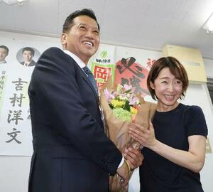 大阪選挙区で当選を決め、花束を受け取る日本維新の会の岡崎太氏=20日夜、大阪市東成区