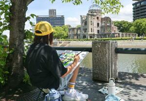 広島市の平和記念公園で開かれた写生大会で、原爆ドームを描く浅井希光さん=19日午前