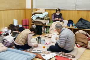 黒埼市民会館に設けられた避難所に身を寄せる70代男性と家族=4日、新潟市西区鳥原