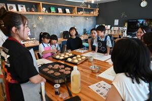 ハンバーガーづくりの「きょうしつ」を開いた久松希美さん(左)=2025年7月