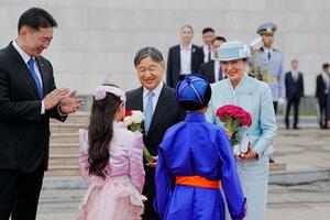 訪問先のモンゴルの歓迎式典で、子どもたちからの花束を受け取られる天皇、皇后両陛下=8日、ウランバートルのスフバートル広場(共同)