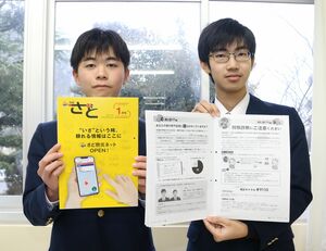 自分たちが手がけた市報を手に、制作エピソードを語る羽茂高校の渡辺真さん(右)と村川凛太郎さん=1月8日、佐渡市羽茂本郷