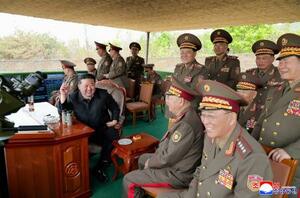 　北朝鮮軍の迫撃砲の訓練を視察する金正恩朝鮮労働党総書記（手前右から３人目）＝２５日（朝鮮中央通信＝共同）