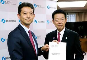 武藤経産相(右)に洋上風力発電の事業推進を求める要望書を手渡す千葉県の熊谷俊人知事=18日午後、経産省