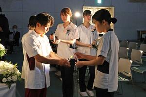 継灯式で看護への決意を示した長岡崇徳大の学生=16日、長岡市深沢町
