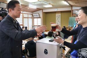 試飲会でおかわりを求める人が続き笑顔の髙木千歩さん（右）＝十日町市松之山観音寺
