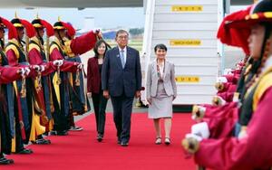 韓国・釜山の金海国際空港に到着し、出迎えを受ける石破首相。右は妻の佳子さん=9月30日(共同)