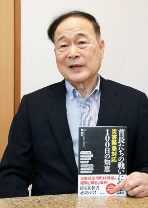 書籍「首長たちの戦いに学ぶ」を手に編集した思いなどを語る森民夫さん=長岡市