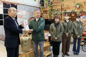 池内博・協栄信用組合理事長（左）から目録を受け取る、青柳修次・フードバンクつばめ理事長（左から２人目）＝燕市仲町